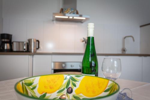 a bottle of wine and a bowl on a table with a glass at Ferienwohnungen Knippschild in Lofer