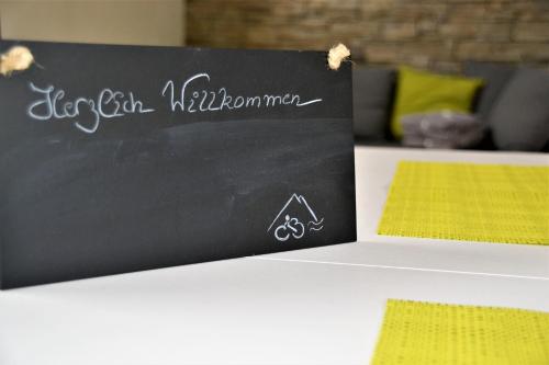 un cartello con la lavagna seduto sopra un tavolo di Casa Bicicletta a Fuschl am See
