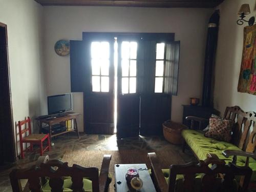 a living room with a green couch and a door at Casa da Tia Luísa in Montoito