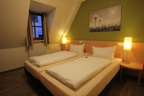 two beds in a small room with two lamps at Gasthof Weißes Roß in Kleinostheim