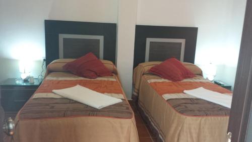 two beds in a room with two lamps at Pension Gran Plaza in Seville