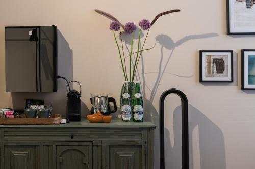 a vase with purple flowers sitting on top of a cabinet at Villa360 in Amsterdam