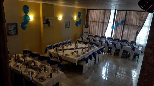 un comedor con mesas, sillas y globos azules en Хотелски Комплекс Родина en Mizara