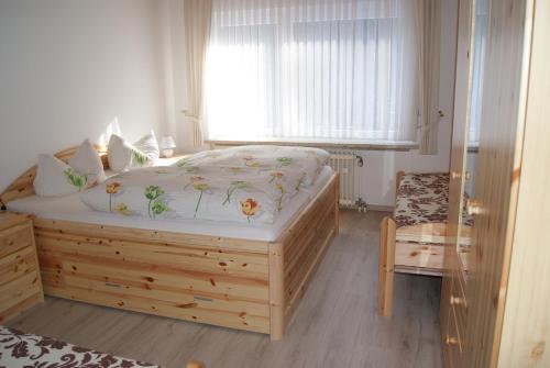 ein Schlafzimmer mit einem Bett, einem Fenster und einem Stuhl in der Unterkunft Ferienwohnung Schmidt in Braunlage