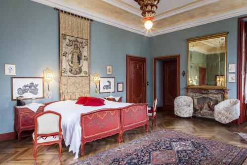 a bedroom with a large bed with red furniture at Villa Cernigliaro Dimora Storica in Sordevolo