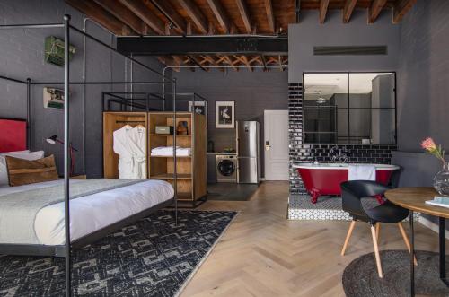 a bedroom with a bed and a bathroom with a tub at Old Foundry Hotel in Cape Town
