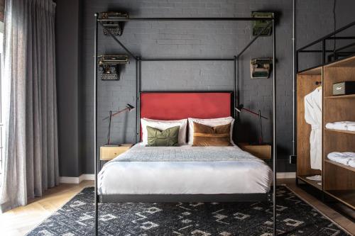a bedroom with a bed with a red headboard at Old Foundry Hotel by Ideas Cartel in Cape Town