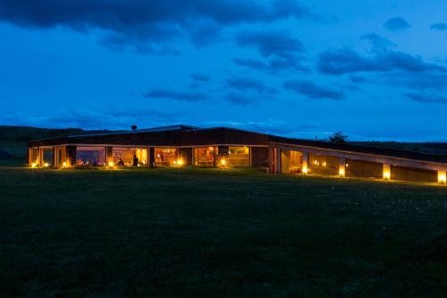 a house with lights in a field at night at Hotel Altiplanico Puerto Natales in Puerto Natales