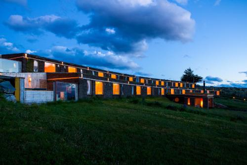 a house with a bridge in a field at Hotel Altiplanico Puerto Natales in Puerto Natales