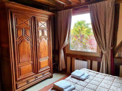 a bedroom with a dresser and a bed and a window at La Venelle Saint Jean in Honfleur