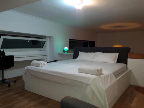 - une chambre avec un grand lit blanc et un bureau dans l'établissement BRIGHT MEZZANINE FLAT WITH GARDEN, à Athènes