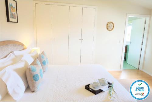 a bedroom with a white bed with a tray on it at Casa dos Edras in Miranda do Douro
