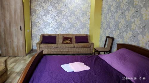 Port Imeni Leninaにあるкрасивая 2-комн. квартира в центре Запорожьяのベッドルーム1室(紫のシーツとソファ付)