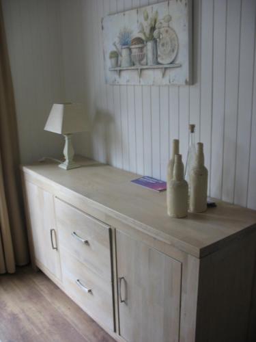 a wooden dresser with a lamp and bottles on it at DURBUY Kleine familiechalet EDELWEISS 4 à 5 pers in Durbuy