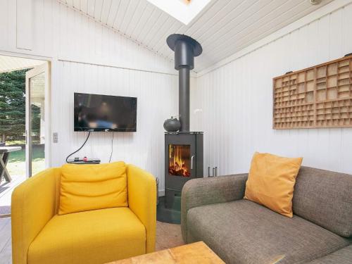 a living room with a couch and a fireplace at 8 person holiday home in Hj rring in Lønstrup