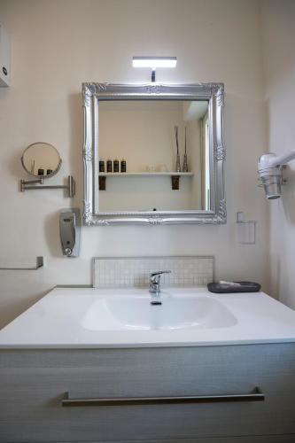 a bathroom with a white sink and a mirror at Come sentirsi a casa in Piacenza