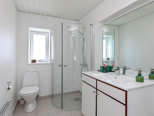 y baño con ducha, aseo y lavamanos. en Three-Bedroom Holiday home in Løkken 38, en Løkken