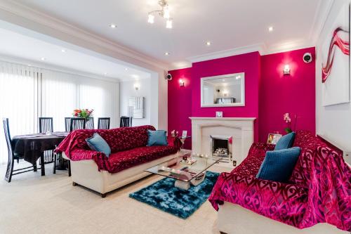 a living room with red walls and a fireplace at Brooklyn House in Barnet