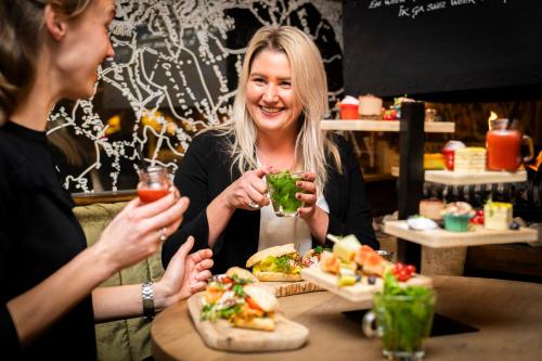 two women sitting at a table eating food at Boutique Hotel De Smulpot in Den Burg