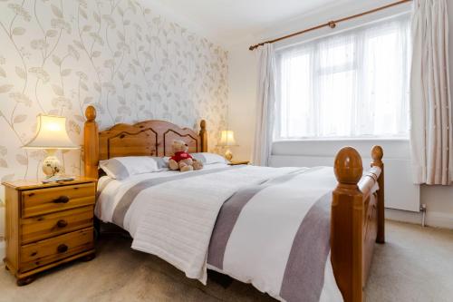 a bedroom with a bed with a teddy bear on it at Brooklyn House in Barnet