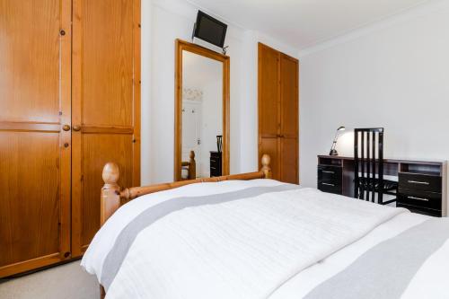a bedroom with a bed and a dresser and a mirror at Brooklyn House in Barnet