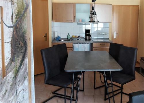 - une cuisine avec une table et des chaises dans la chambre dans l'établissement Ferienwohnung Poeler Möwe, à Poel