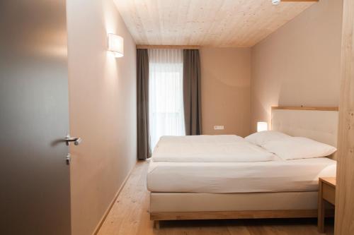 a bedroom with a white bed and a window at Friedlwirt-Kraftplatz Natur in Unken