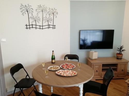 a dining room with a table with two pizzas on it at L'Escale Fougeraise in Fougères