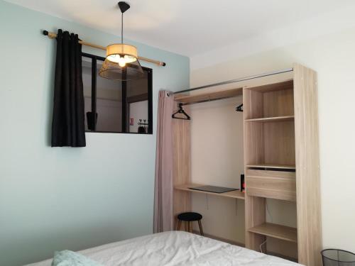 ein Schlafzimmer mit einem Bett und einem Bücherregal in der Unterkunft L'Escale Fougeraise in Fougères