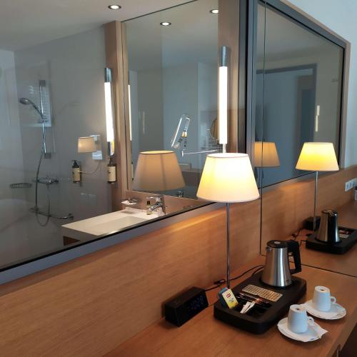 La salle de bains est pourvue d'un miroir, d'un lavabo et de 2 lampes. dans l'établissement Best Western Premier Hôtel du Vieux-Port, à La Ciotat