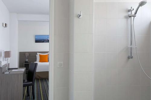 a bathroom with a shower and a bedroom with a bed at Best Western Hôtel des Thermes - Balaruc les Bains Sète in Balaruc-les-Bains