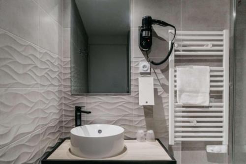 a bathroom with a white sink and a mirror at Best Western Hôtel des Thermes - Balaruc les Bains Sète in Balaruc-les-Bains