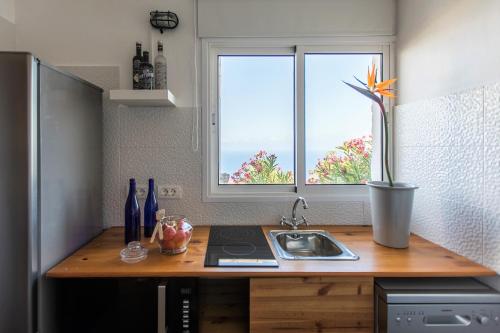 a kitchen with a counter with a sink and a window at ZenRepublic, your private villa with outdoor jacuzzi & pool with stunning ocean views in Puntillo del Sol