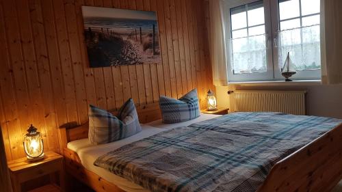 een slaapkamer met een bed met blauwe kussens en 2 verlichting bij Birkenhof Neuharlingersiel in Neuharlingersiel