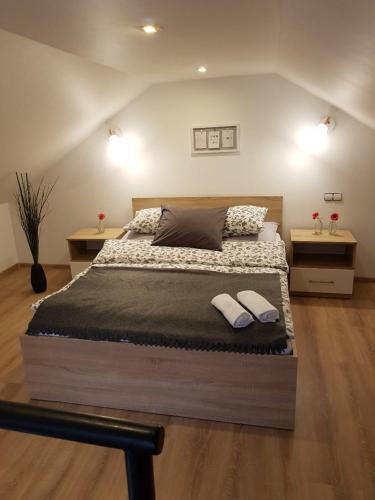 ein Schlafzimmer mit einem großen Bett mit zwei Hausschuhen darauf in der Unterkunft Willa Sandra in Szczawnica