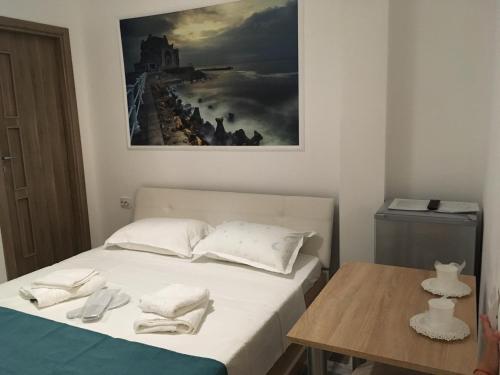 a bed in a room with a painting on the wall at EUROPEAN HOUSE in Constanţa