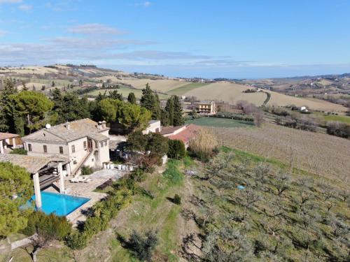 an aerial view of a house in the hills with a pool at La casa nella Vigna in Montegranaro