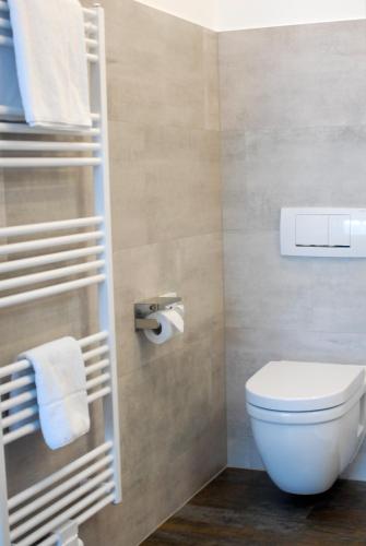 a bathroom with a toilet and towels at Hotel ZweiLinden Meckenheim Bonn in Meckenheim