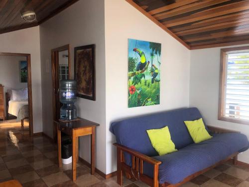 a living room with a blue couch in a room at Colinda Cabanas in Caye Caulker