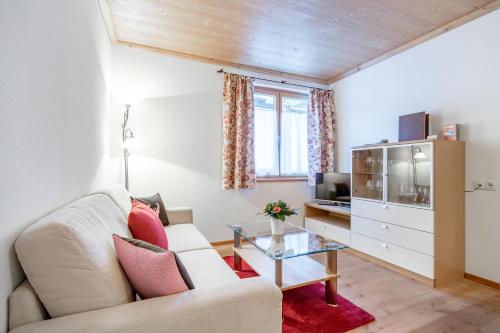 a living room with a white couch and a glass table at Bühlhof Appartements in Lech am Arlberg