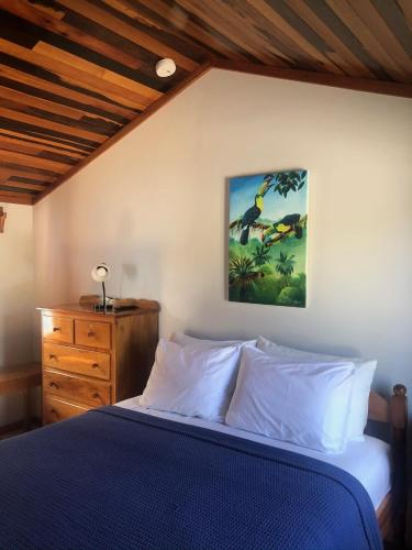a bedroom with a bed and a painting on the wall at Colinda Cabanas in Caye Caulker