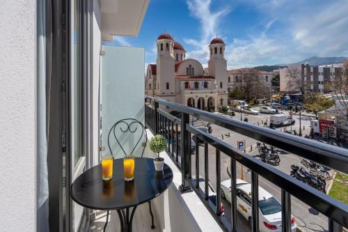 a balcony with a table and a view of a city at White & Gray apartment in Rethymno