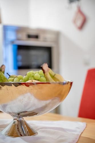 a bowl of green and yellow fruit on a table at Bühlhof Appartements in Lech am Arlberg