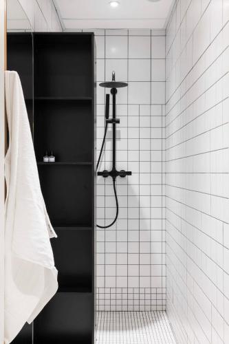 a bathroom with a shower with black and white tiles at CENTRAL Hostel Bordeaux Centre in Bordeaux