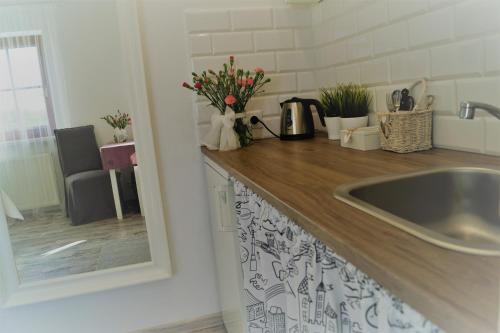 a kitchen counter with a sink and flowers on it at Pokoje Gościnne Puławska 41 in Kazimierz Dolny