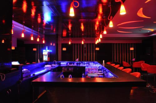 a bar in a nightclub with red and blue lights at Gokulam Park Coimbatore in Coimbatore
