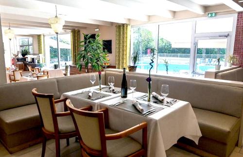a dining room with a table with wine glasses at Kyriad Prestige Mulhouse - Basel in Sausheim