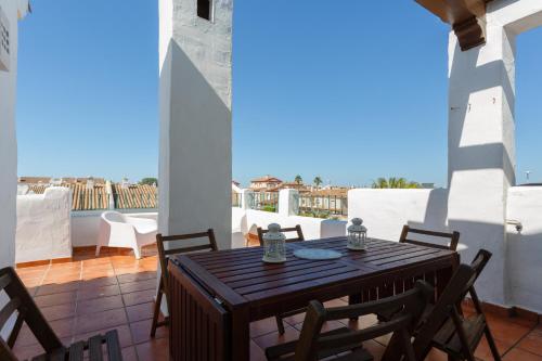 patio con mesa y sillas en el balcón en Atico La LUZ-Rota free parking by Cadiz4Rentals, en Rota