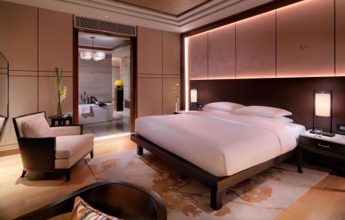 a bedroom with a large bed and a bathroom at Hyatt Regency Chongming in Chongming