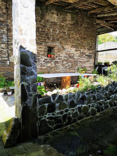 a stone building with a window and a stone wall at Pensión Santa Rosa in Samos